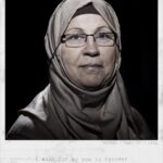 A portrait of an older woman wearing glasses and a headscarf, looking directly at the camera. The caption reads, “Batool / Age: 60 / Iraq. I wish for my son to recover from cancer.”.