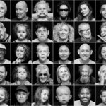 A grid of 42 black and white portraits featuring a diverse range of individuals of various ages, genders, and expressions. Some people are smiling, others are serious, and a few are making playful faces. The background is uniformly black in all portraits.